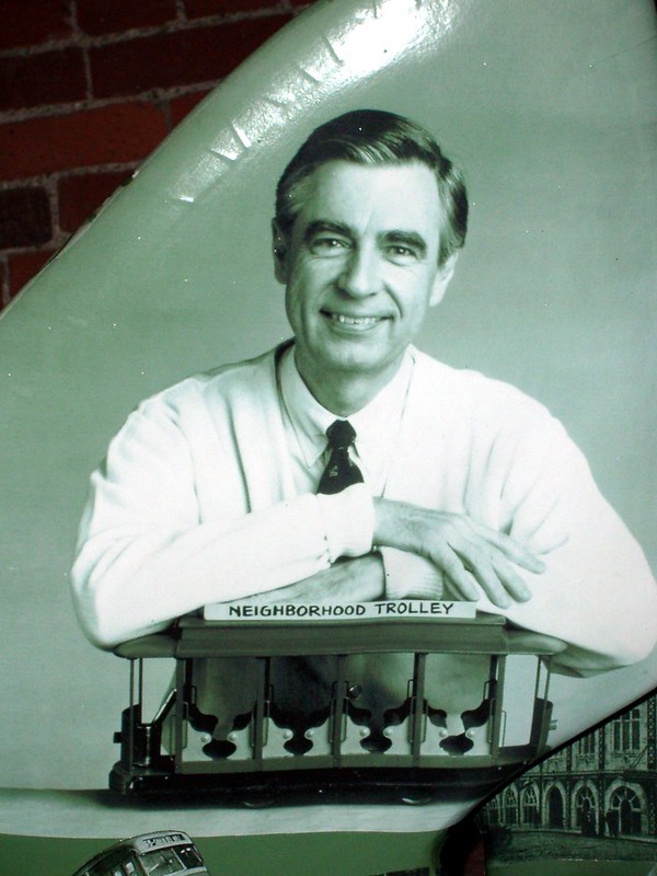 Black and White picture of Fred Rogers with his arms on the trolley from Mister Rogers' Neighborhood